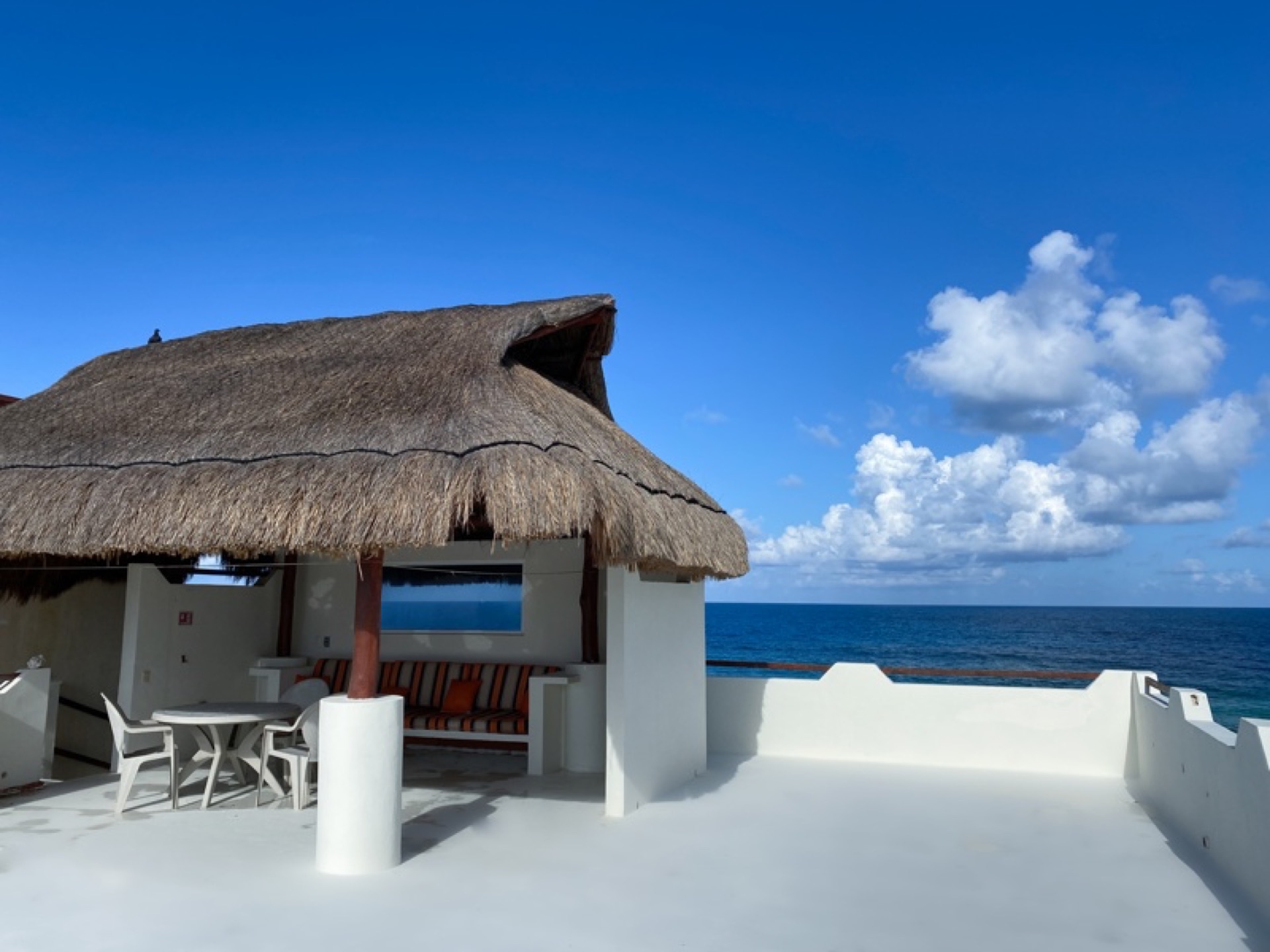 Rooftop palapa with thatched roof and ocean backdrop — Isla Mujeres