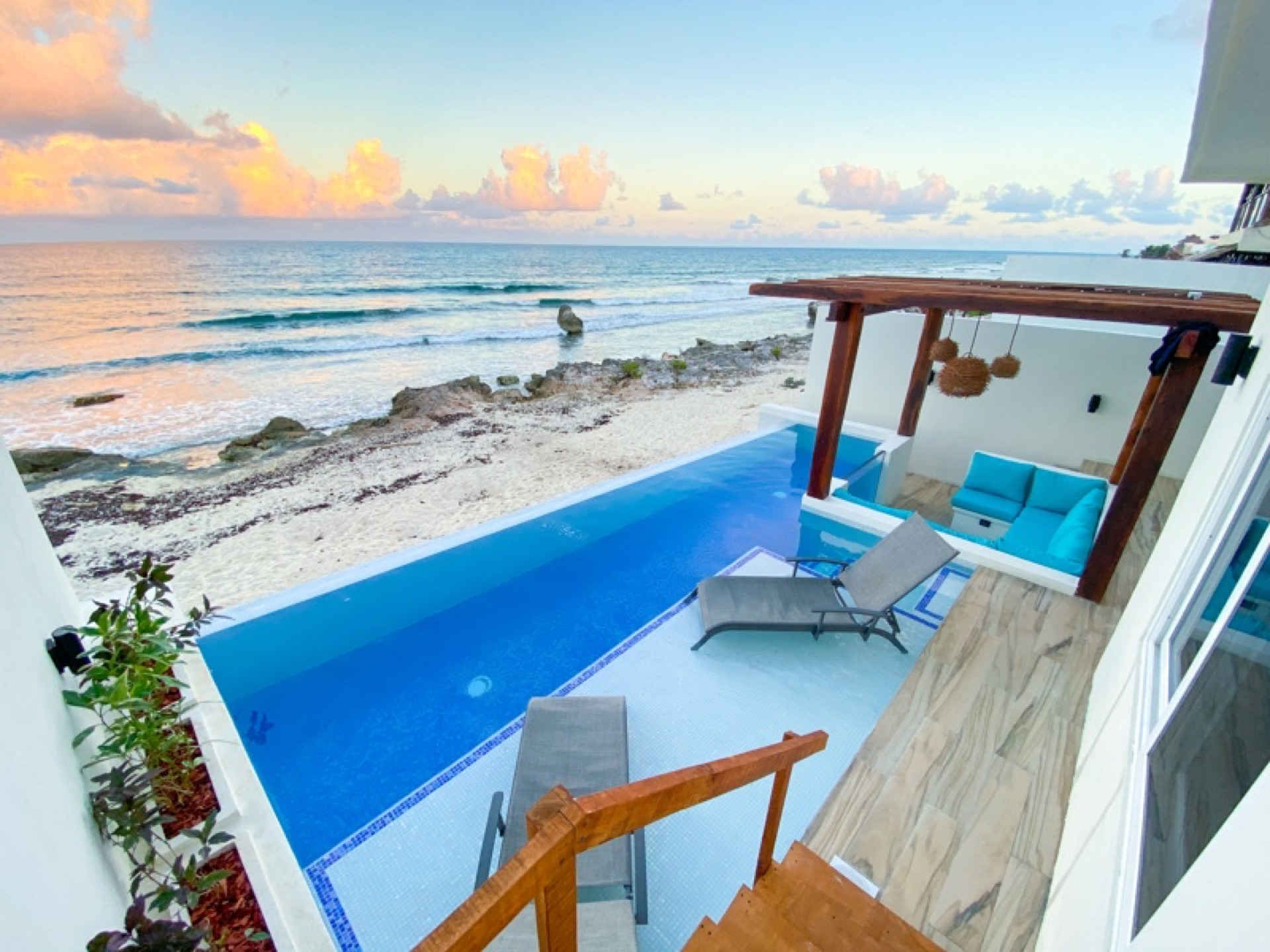 Pool and pergola with ocean and rocks — beachfront vacation rental Isla Mujeres