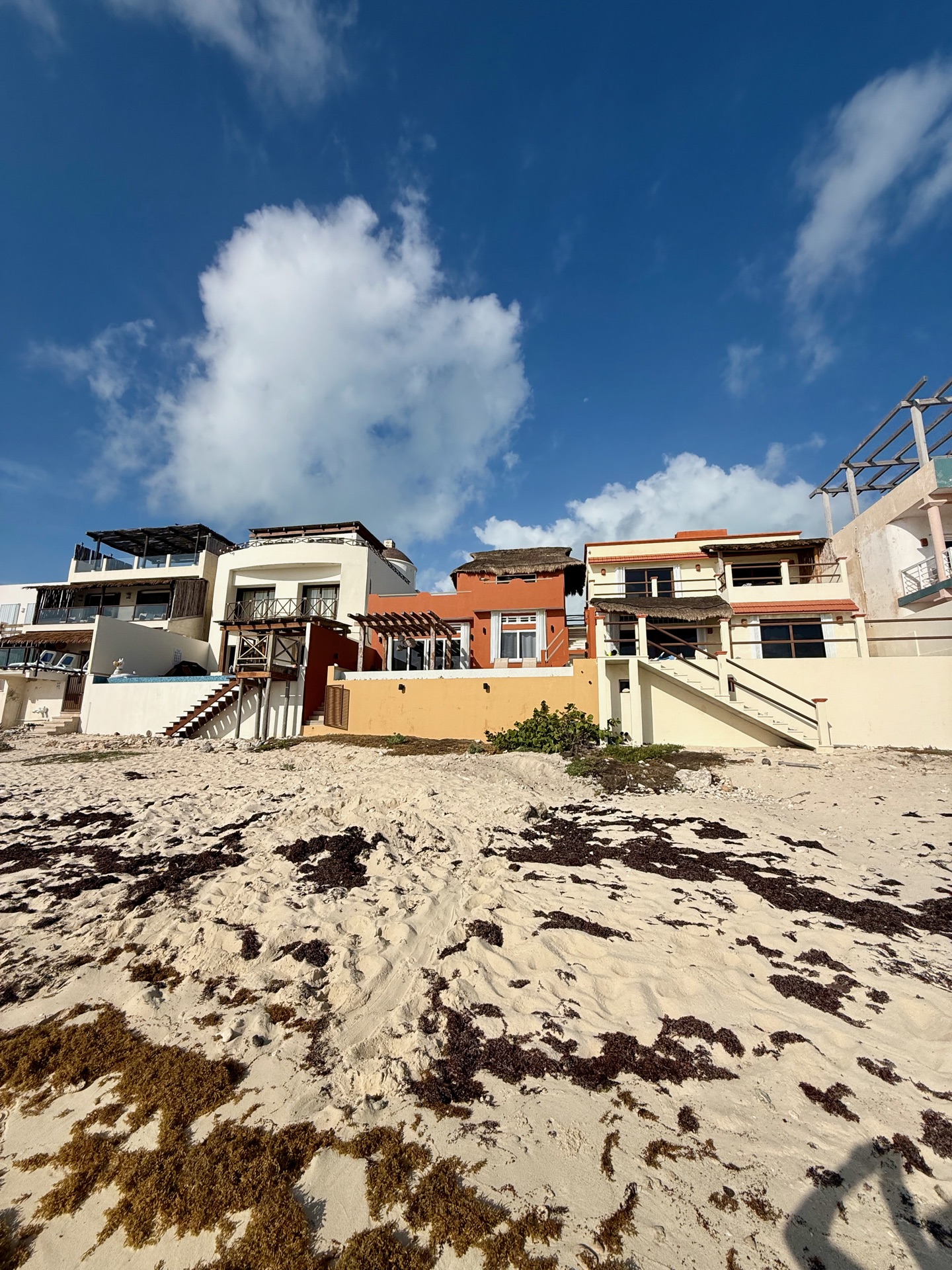 Terra cotta beachfront exterior with palapa roof — Rincón del Descanso Isla Mujeres