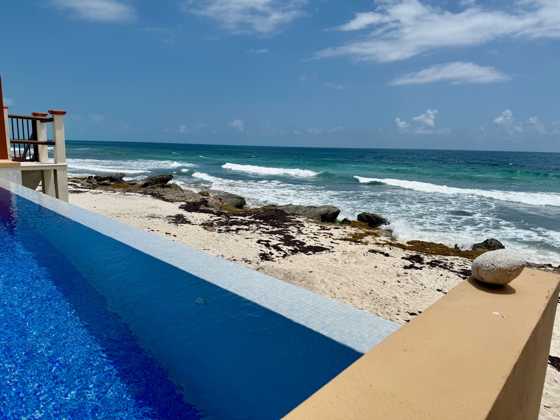 Pool ledge with coral and shells overlooking the beach Isla Mujeres